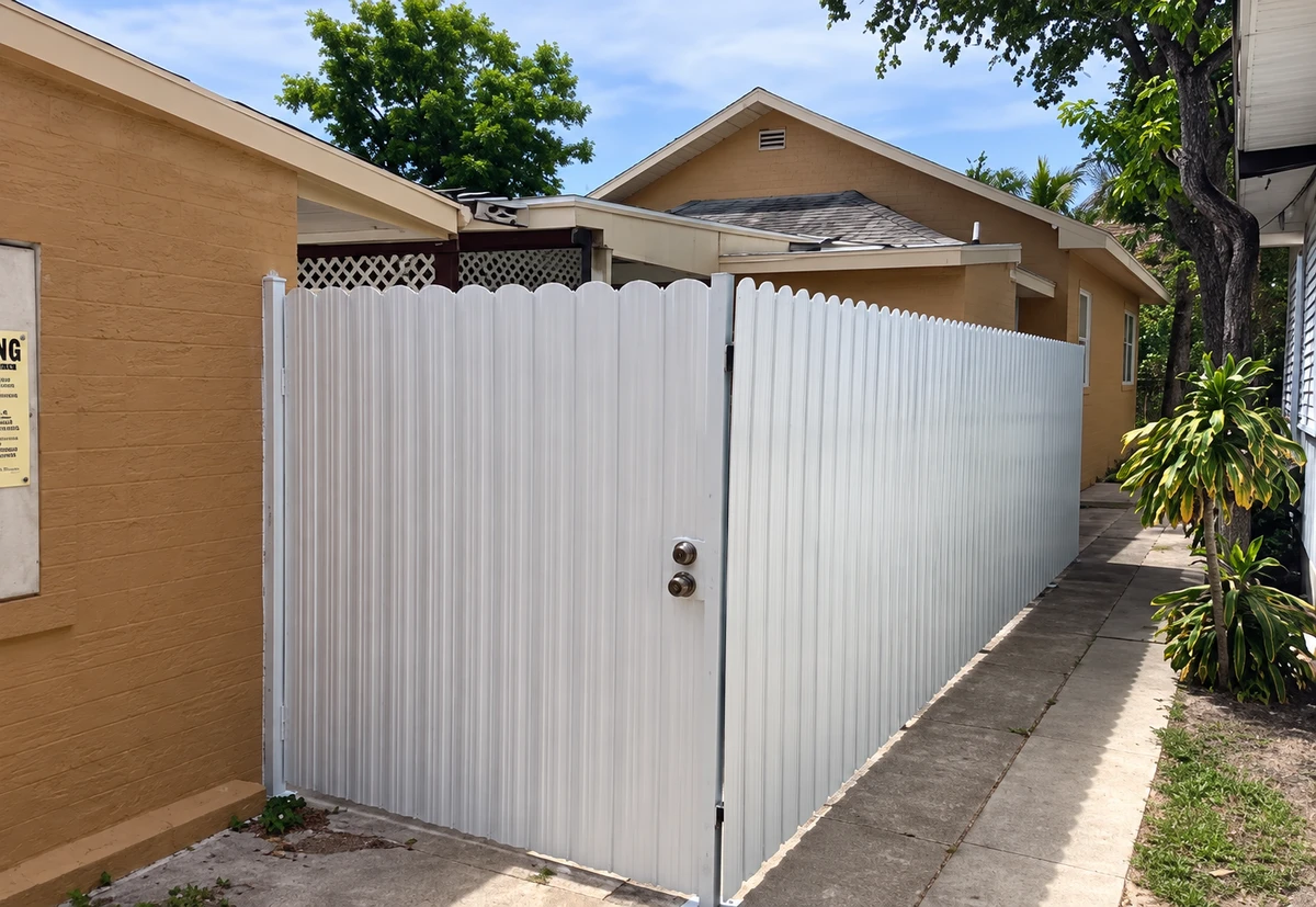 White metal pedestrian gate alongside a matching privacy fence